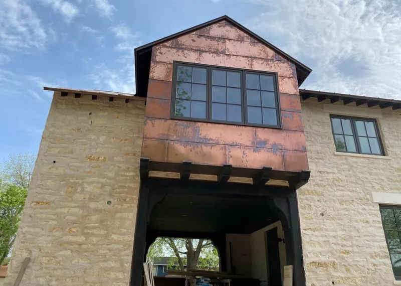 Copper metal panel facade on a stone building for Roof Repair in Monahans